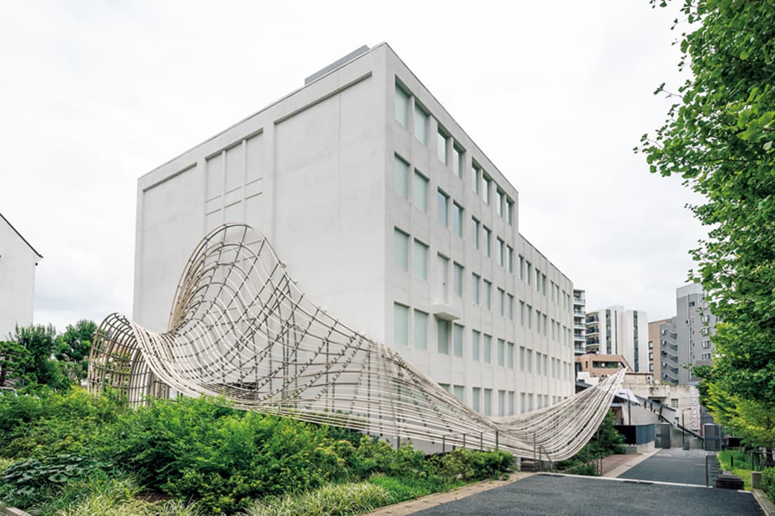 〈早稲田大学国際文学館（通称：村上春樹ライブラリー）〉の、真っ白い箱型の建物に木製の庇が絡みつく外観。『カーサ ブルータス』2021年11月号より。photo_GION   text_Sawako Akune