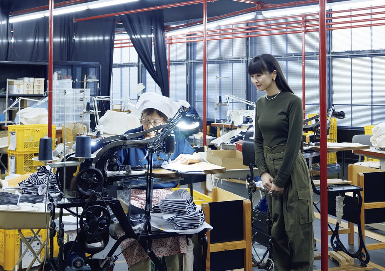 At Kineya Tabi, established 1929. Gyōda tabi, along with the tabi-gura, the building in which the tabi are stored, are officially recognized as artifacts of Japan’s National Heritage. Thrilled by watching the toe portion being stitched, KASHIYUKA marveled at the multitasking involved, exclaiming, “it’s like playing an electronic instrument!”