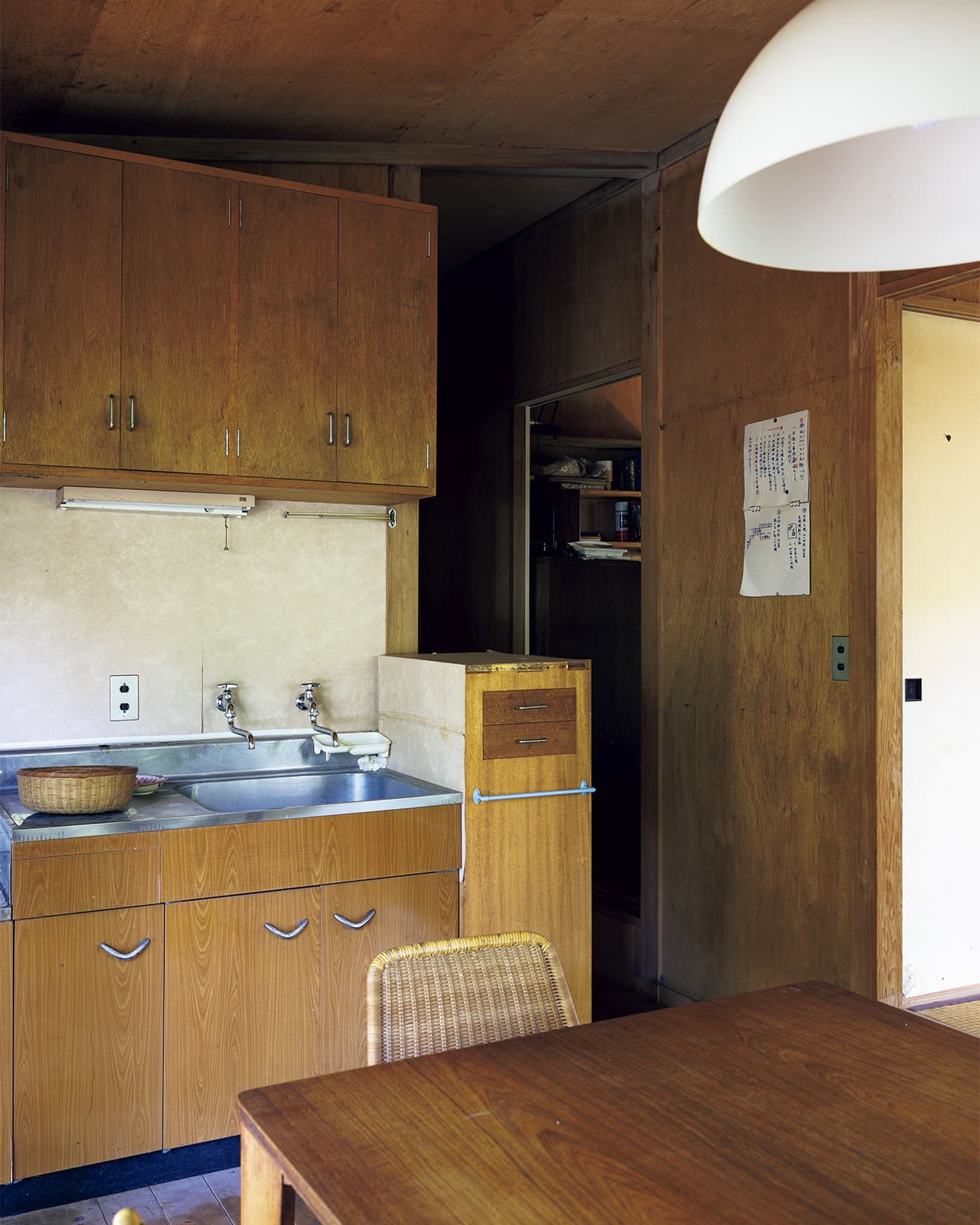 キッチンの吊り戸棚は吉村順三の設計。右手には三畳間の寝室がある。