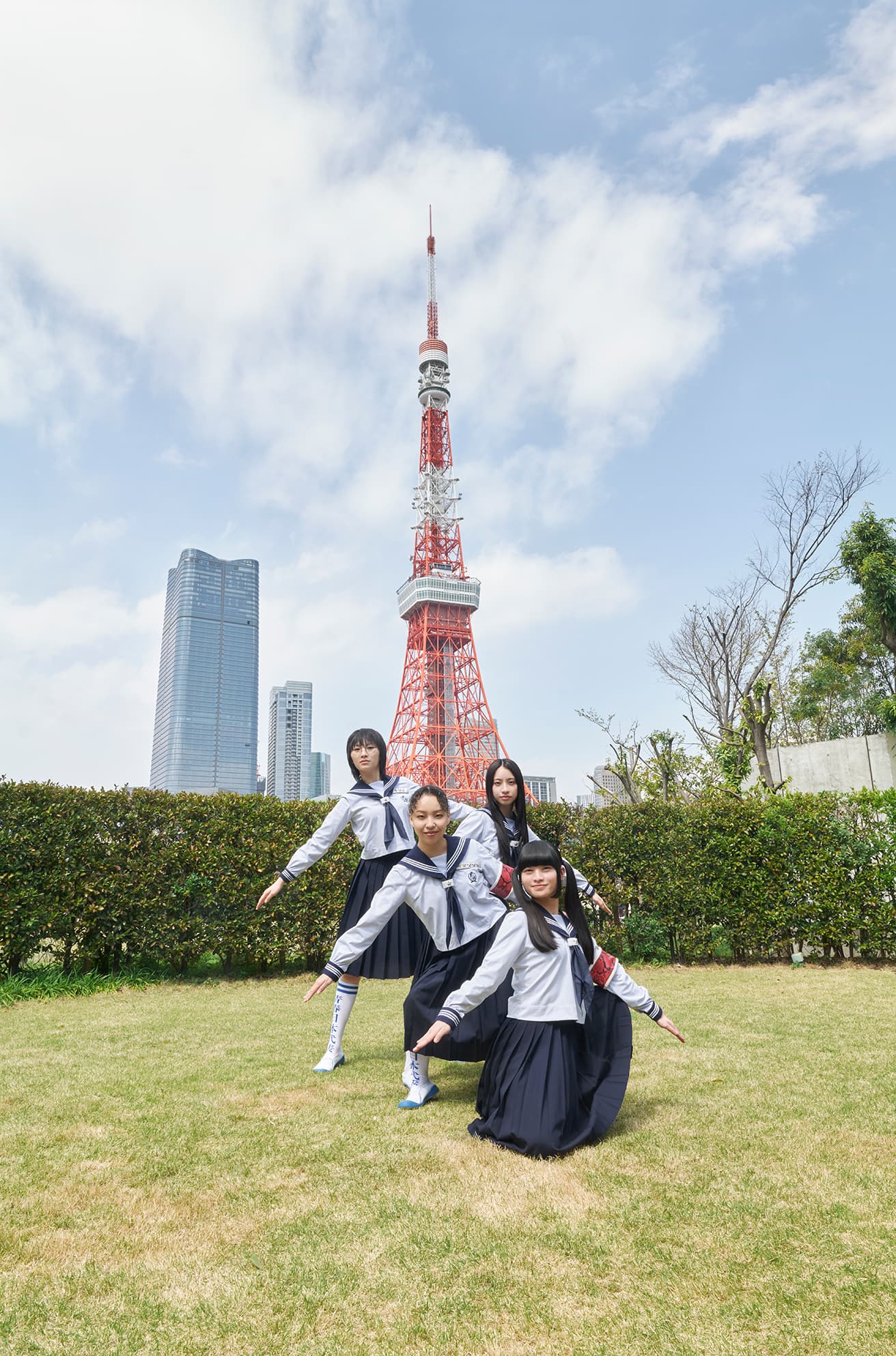高さ333mの東京タワーをバックに〈ザ・プリンスパークタワー東京〉の神殿「神明」の芝生の上でポーズを取る、新しい学校のリーダーズ。