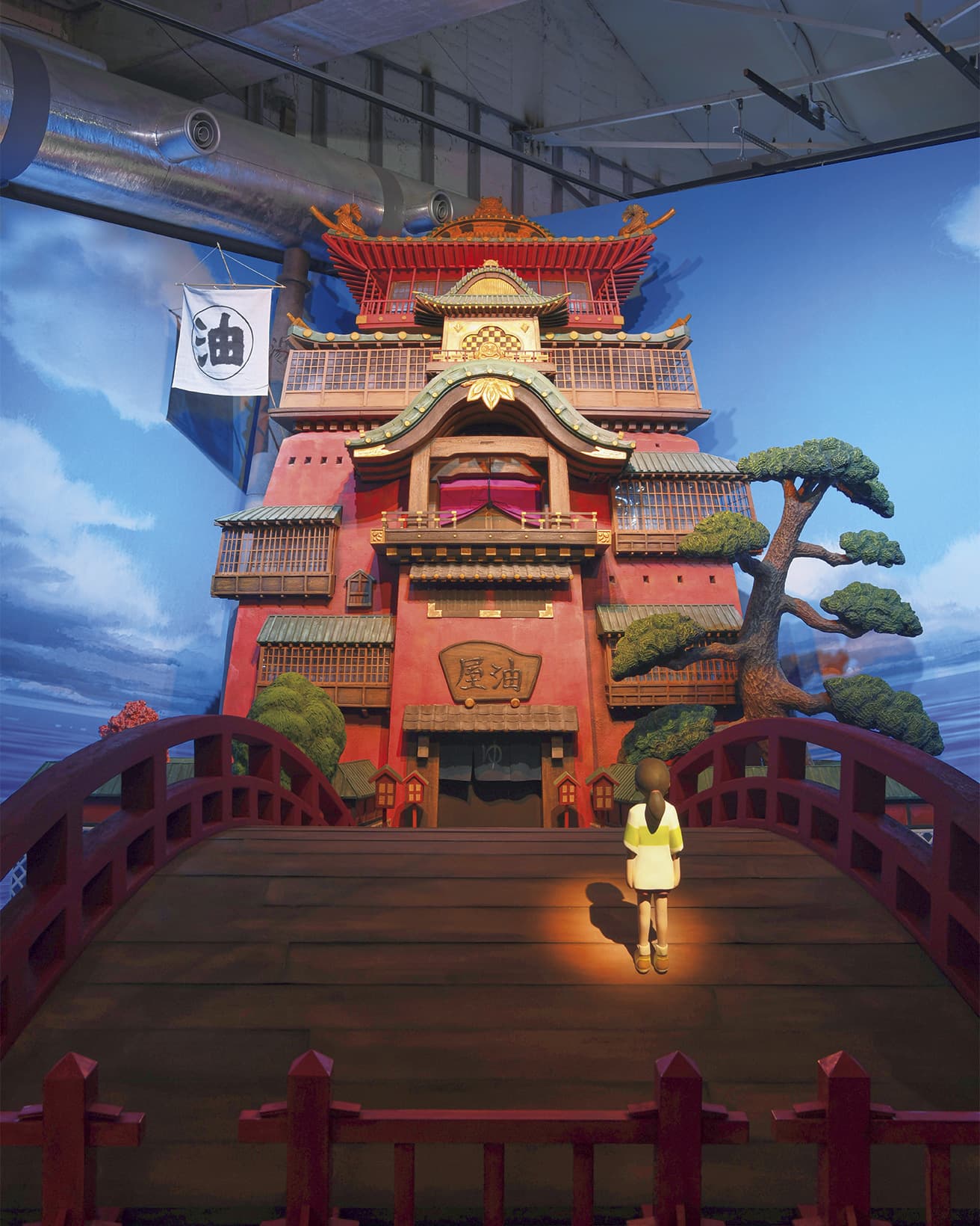 『千と千尋の神隠し』に登場する「油屋」。　遠近法と目の錯覚の効果を高めるアーチ状の赤い欄干の橋。(c) 2001 Hayao Miyazaki/Studio Ghibli, NDDTM