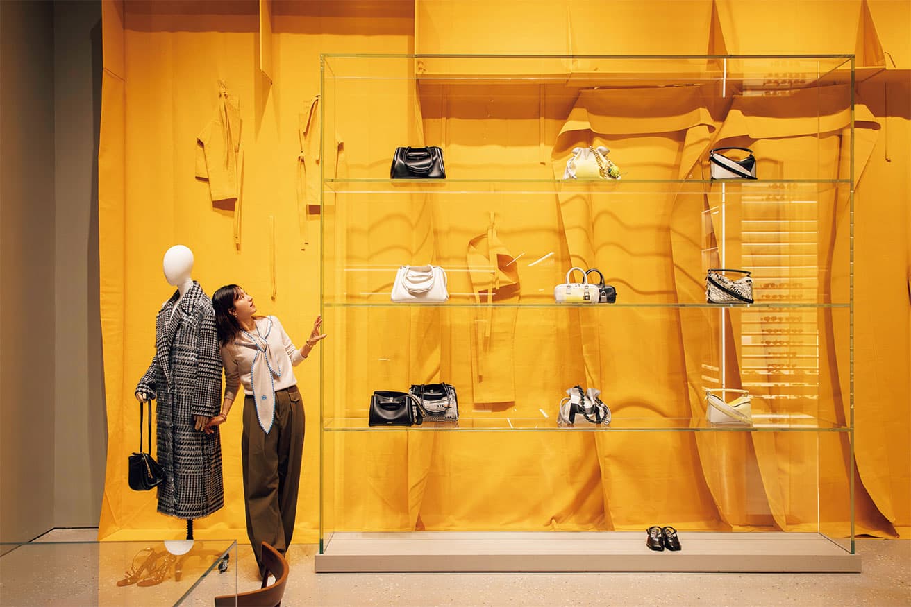 〈CASA LOEWE Montaigne〉現在の店舗に隣接する、かつての店舗だったスペースを改装し、統合する形で11月6日にオープン。562平米という広大なスペースでは、各所に配置された名作家具やアートピースを楽しみながらゆったりとショッピングが楽しめる。壁面にはフランツ・ヴァルターの《Gelbe modellierung》（1985）。パンツやジャケットの断片を融合させた巨大な作品で、2019年秋冬メンズショーの背景を飾った。スカーフ セーター214,500円（予定価格）、パンツ196,900円（予定価格）、ピアス59,400円、カフ210,100円、ブレスレット38,500円（ロエベ ジャパン クライアントサービス TEL 03 6215 6116）。