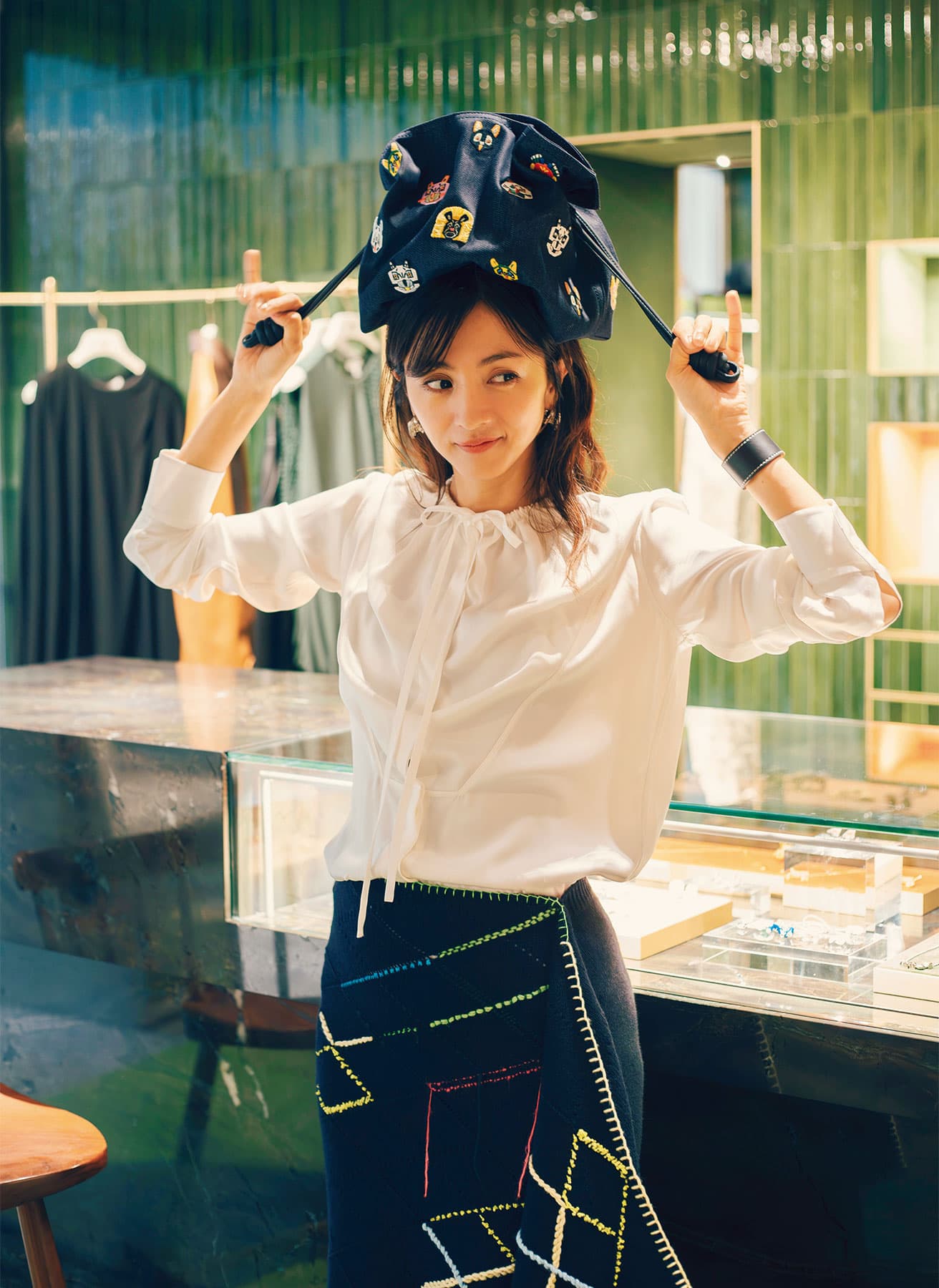 グリーンのセラミックタイルに柔らかな光が反射し、窓からは美しいパリの街並みが望める2階部分。満島さんが手にしているのは、ショーでも身につけていたバッグ《フラメンコクラッチ》の新作。バッグ48万6200円（予定価格）（ロエベ ジャパン クライアントサービス TEL 03 6215 6116）。