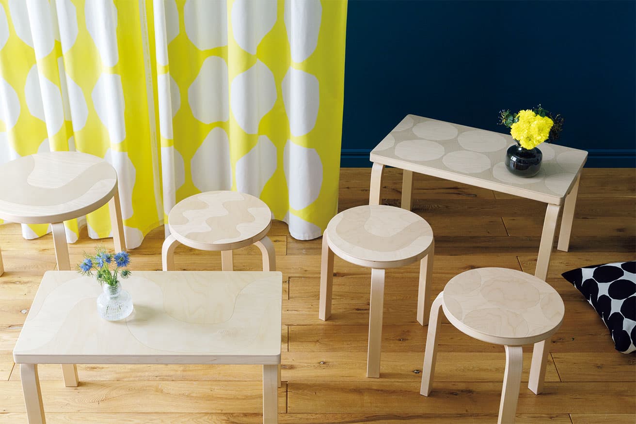 「アルテック＋マリメッコ」右から《ベンチ 153B キヴェット》《スツール 60 キヴェット》《スツール 60 セイレーニ》《ベンチ 153B セイレーニ》《スツール 60 ロッキ》。ベンチ各115,500円、スツール各53,900円。《テーブル 90D セイレーニ》121,000円。キヴェット クッションカバー参考商品、フラワーベース右25,300円、左19,800円（ルック ブティック事業部 TEL 03 6439 1647）。