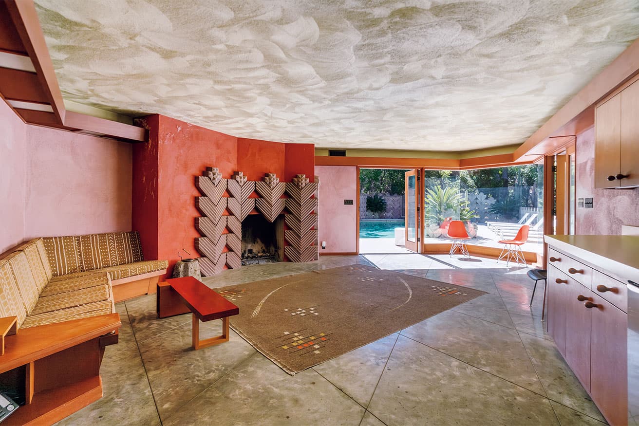 大胆な幾何学的形態とガラス壁が特徴のリビング。