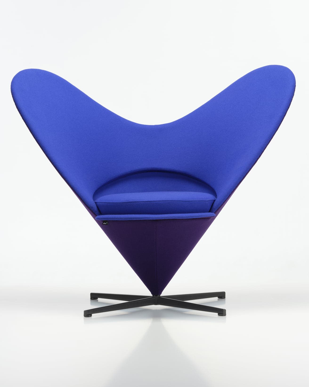 《ハート コーン チェア アニバーサリー エディション 2026》。正面は鮮やかなブルーのテキスタイルを纏う。広がりのあるハート型の背もたれが、快適性に加え、座る人の自由な動きを実現している。