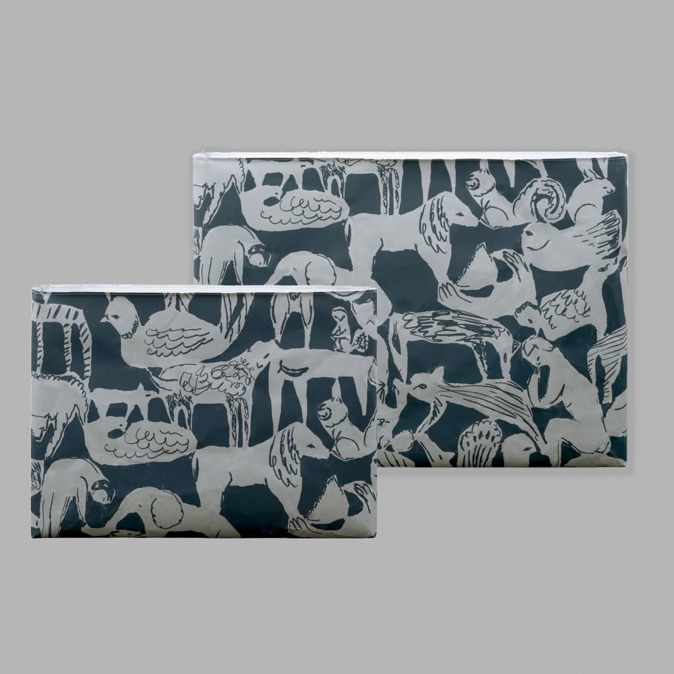 （右）《PC / タブレットケース M》8,140円。W36cm×H28cm×D1.5cm。（左）《PC / タブレットケース iPad》6,820円。W28cm×H21cm×D1.5cm。共に“ life puzzle”の図案。●ミナ ペルホネン インフォメーションデスク TEL 03 5793 3700。