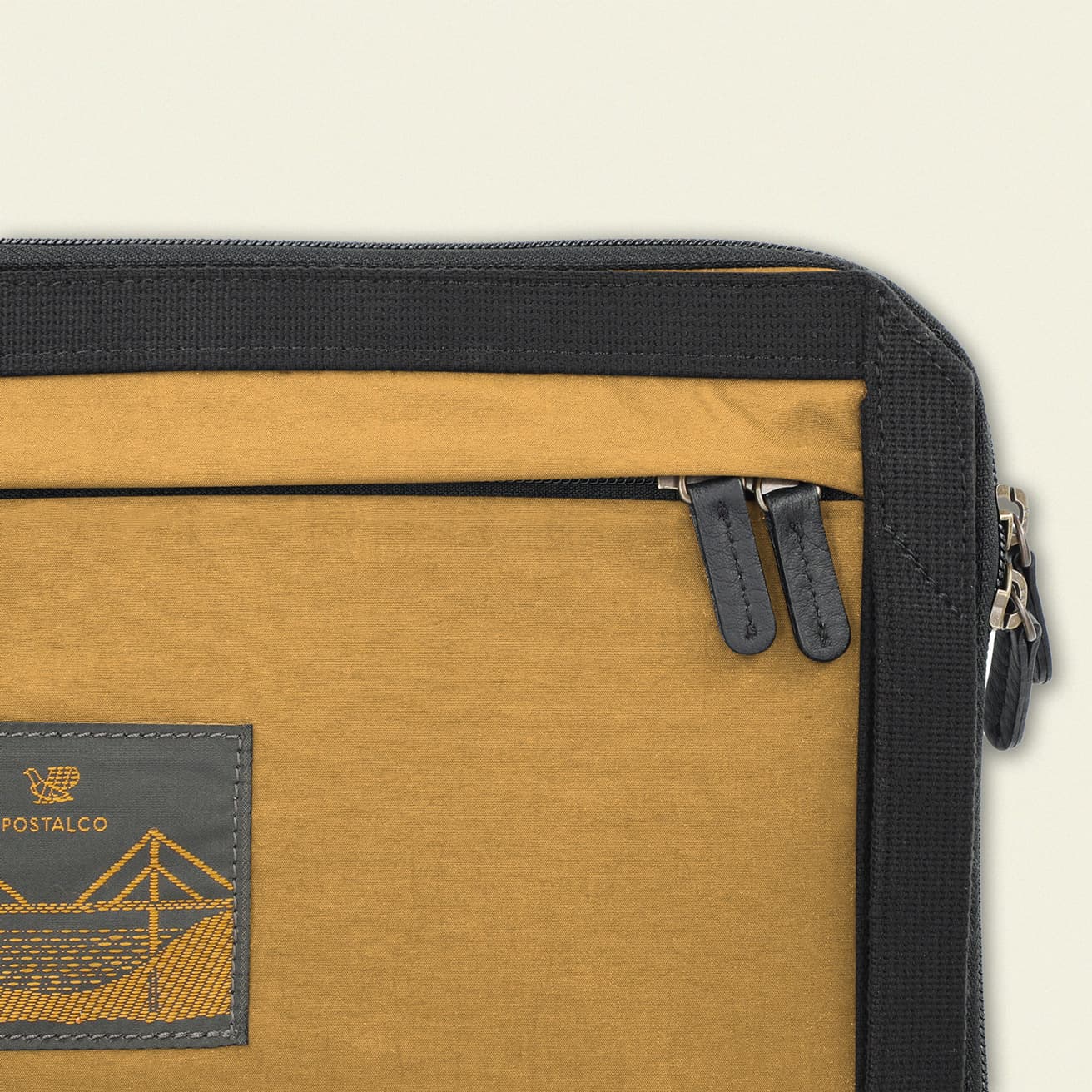 フロントにはジップ付きポケット。引き手には革を使用し、細部までこだわりが。