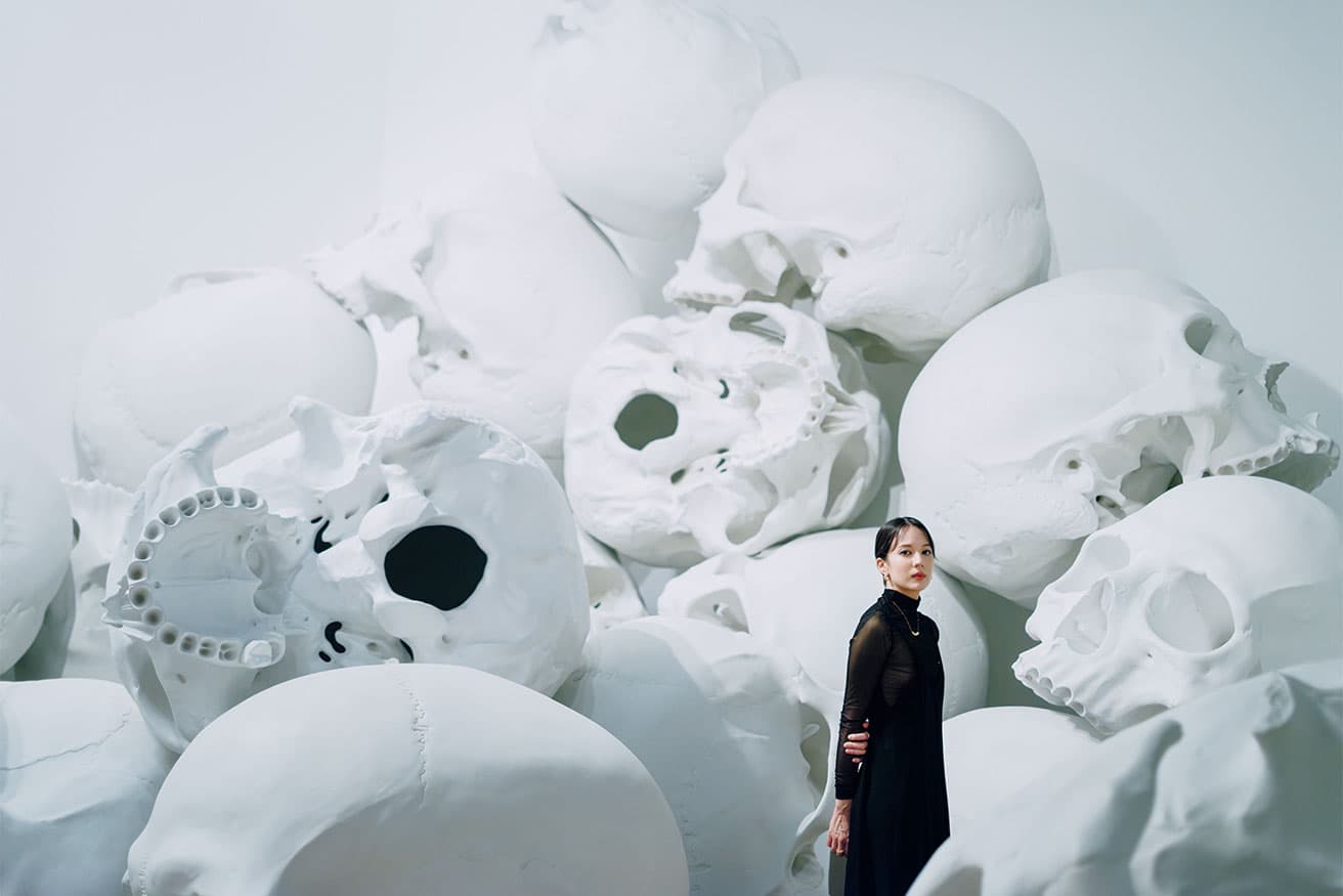 展示の見どころの一つである《マス》の中に佇む、アーティスト・友沢こたお。頭蓋骨は1点1点、微妙に異なる。