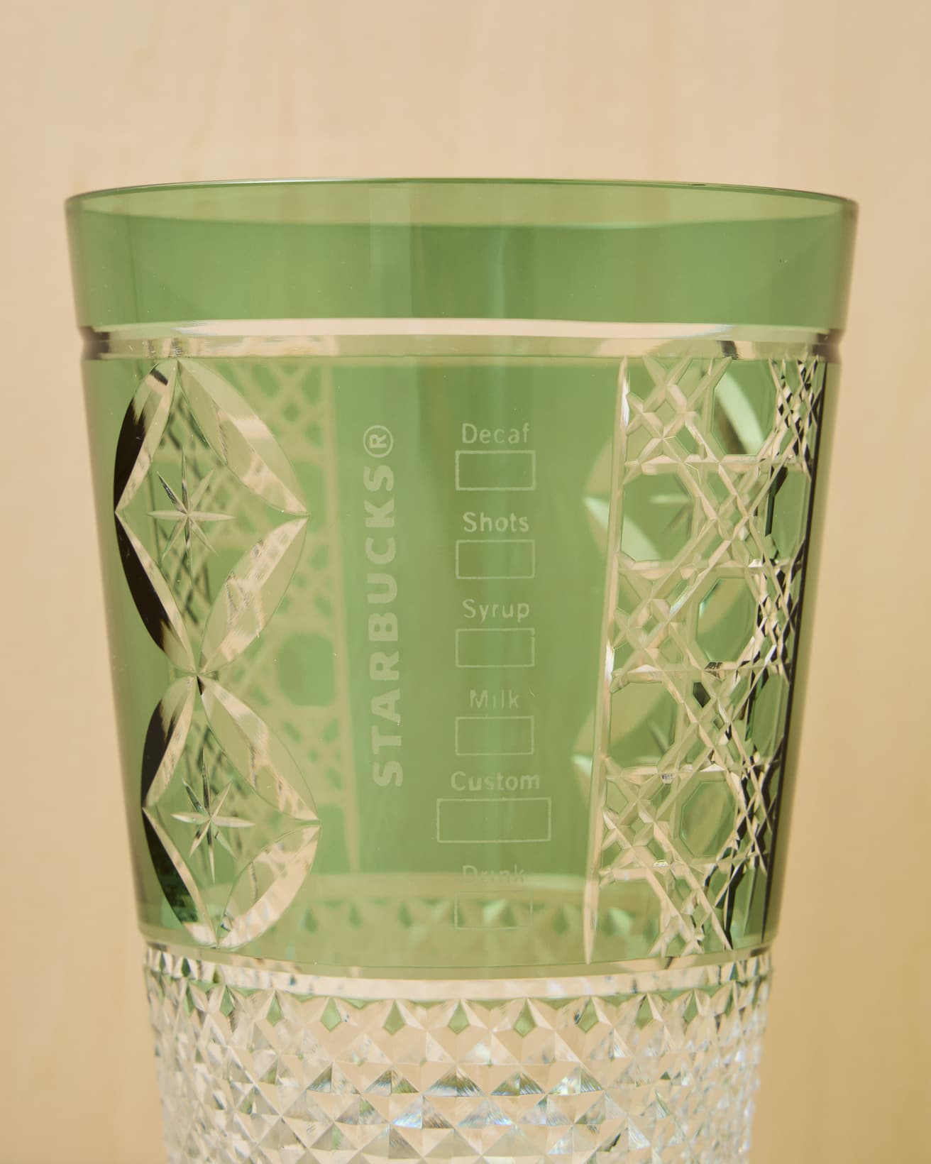 ブランドカラーでもある、グリーンのグラス。七宝（しっぽう）、八角籠目（はっかくかごめ）、あられの3つの伝統的な文様が刻まれている。カスタムボックスとロゴもしっかりと。