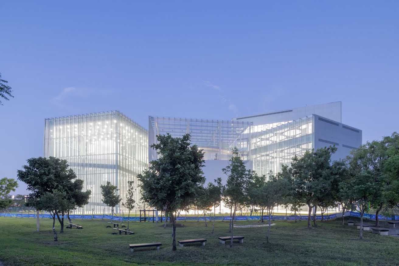 台中中央公園の緑に囲まれた建築。照明が入ると透明度が増す佇まい。photo_courtesy of Taichung Art Museum ©Iwan Baan
