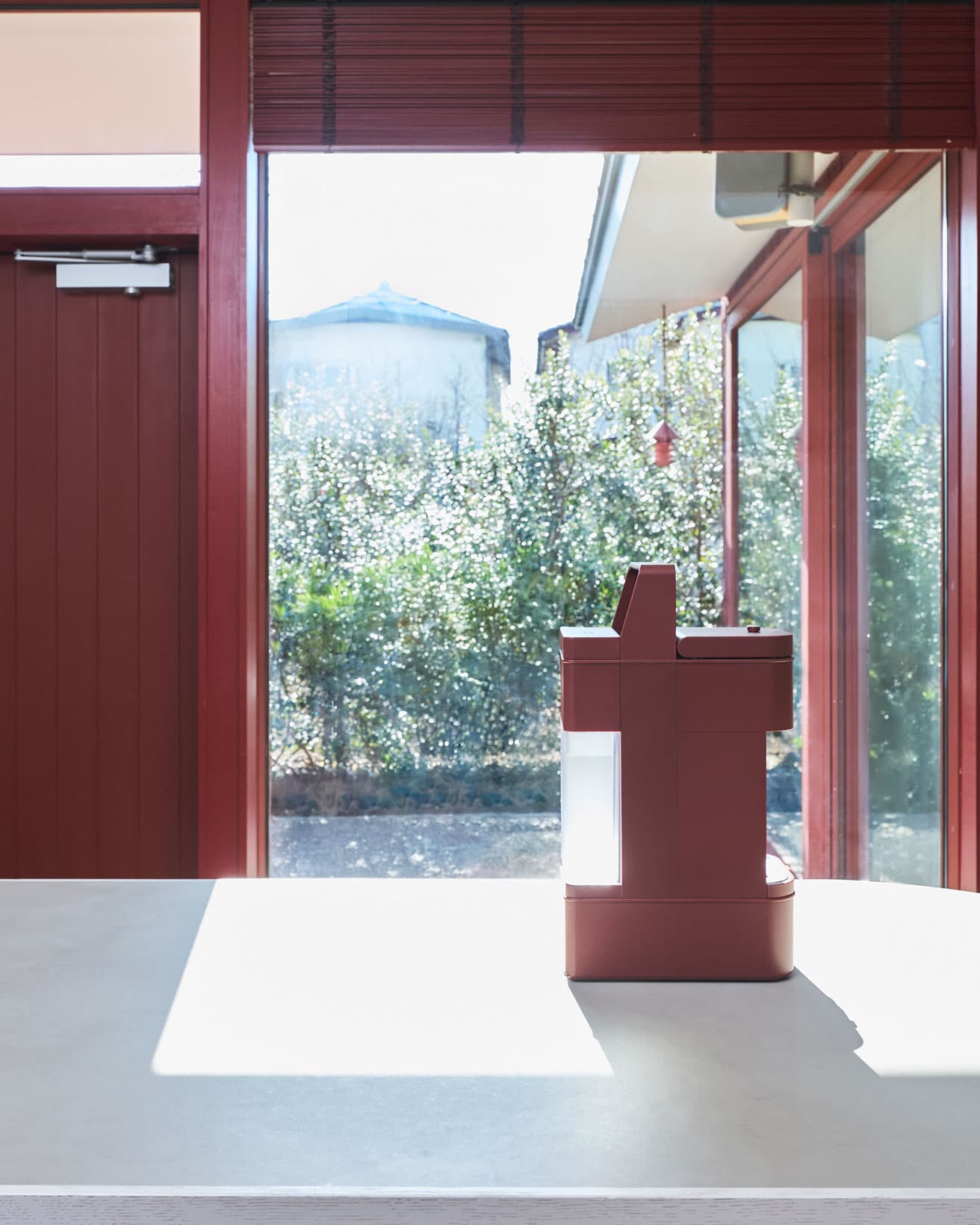 窓枠とブラインドも外壁とつながるベンガラ色。ラッカーレッドの存在感がぴたりとハマる。