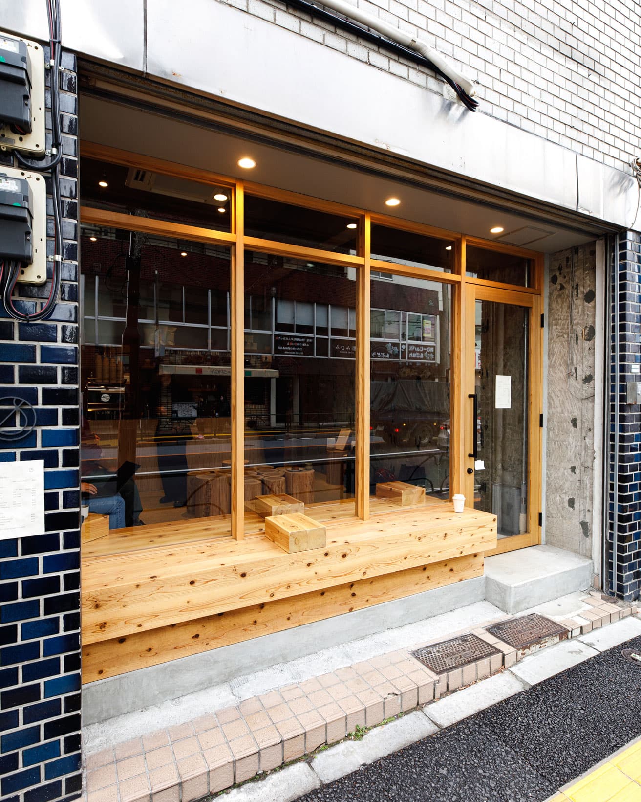 〈COFFEE STAIN -根津-〉外観。杉の木目が美しいベンチ。