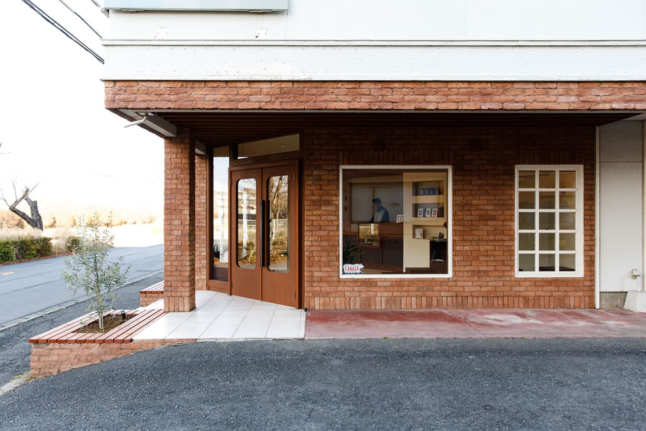 〈L'hirondelle〉外観。煉瓦模様のシックな外装。側面の正方形の窓から、店内を見通すことができる。
