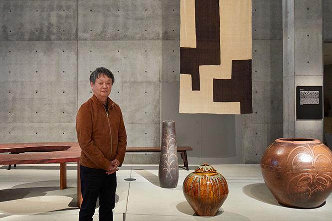 「民藝展」をディレクションしたデザイナーの深澤直人。左後ろに見える《柳デスク》は柳宗理の作品、正面奥の《柳型茶卓》は柳宗悦の意匠。