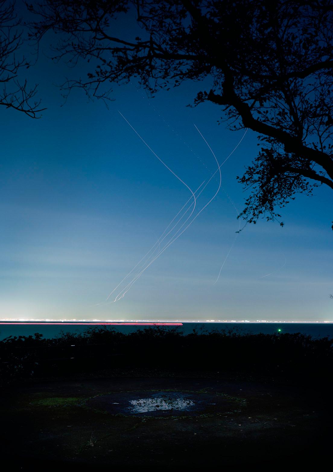 忽那光一郎《風速0 SR08》。飛行機の航跡を長時間露光で撮った写真。