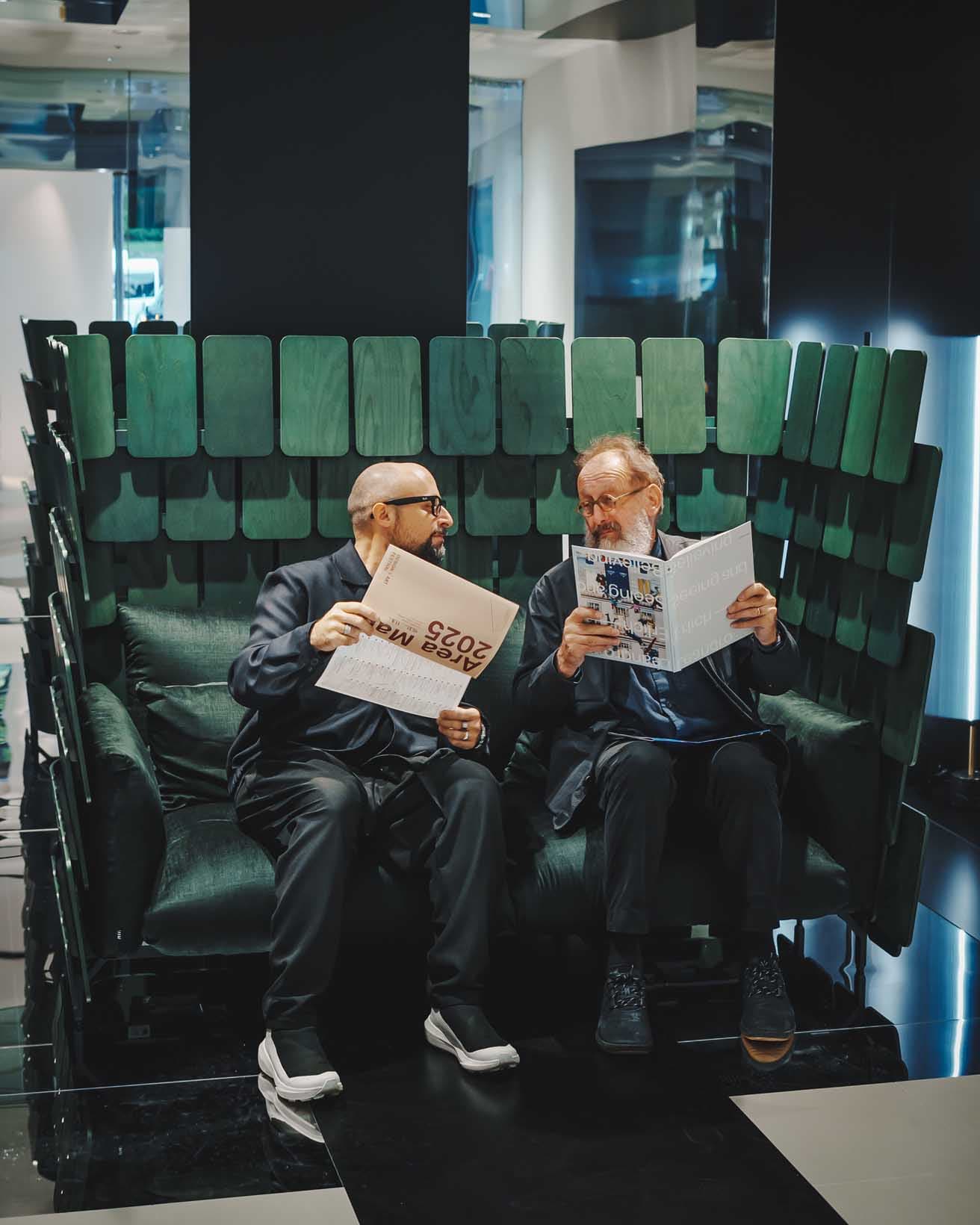 〈AMDL CIRCLE〉を率いるミケーレ・デ・ルッキ(右、ファウンダー)とダヴィデ・アンジェリ(左、デュプティ・マネージング・ディレクター)。彼らがイトーキから発表した新作《PIGNA》に座って仲良く談笑している。